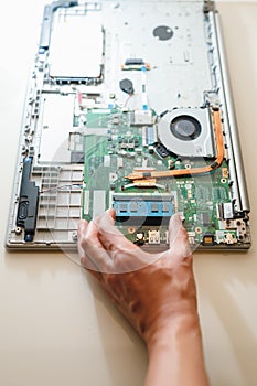 Hand of repairman holding a ram sodimm memory module, laptop upgrade
