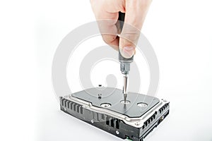 Hand repairman unscrews the 3.5 inch hard drive cover with a screwdriver.