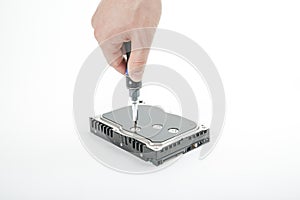 Hand repairman unscrews the 3.5 inch hard drive cover with a screwdriver.