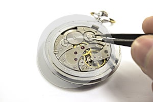 Hand repairs an old mechanical watch. Isolated