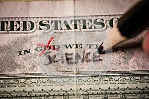 Hand replacing the word god for science on on a US dollar bill