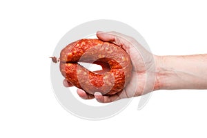 Hand with a ring of tasty smoked sausage on a white background