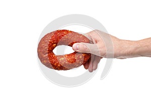 Hand with a ring of tasty smoked sausage on a white background