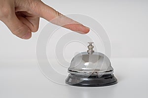 Hand is ringing silver service bell on white background