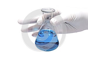 Hand in rubber glove holding chemical flask with blue liquid