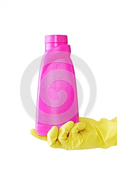 Hand in rubber yellow glove holds pink bottle of liquid bleach on white background. cleaning