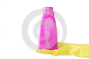 Hand in rubber yellow glove holds pink bottle of liquid bleach on white background. cleaning