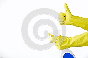 Hand in rubber yellow glove holds spray bottle of liquid detergent on white background. cleaning