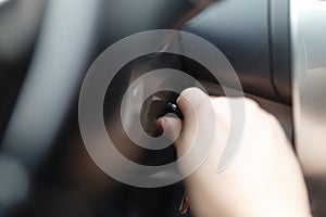Hand s man plug in a key starting the engine of a car.