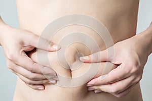 Hand`s man touching his fat belly skin
