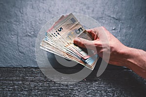 HandÂ´s of young man holding a money. Banknotes on a stone background. Euro money bank notes of different value.