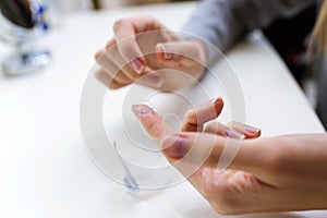 Hand`s of young woman holding one contact lenses before putting on them.