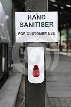 Hand sanitiser dispenser for customer use to wash hands reduce risk of coronavirus virus with liquid sanitizer soap