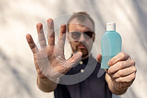 Hand sanitizer alcohol gel rub clean hands hygiene prevention of coronavirus virus outbreak. Man showing one hand and holding a