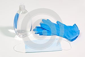 Hand sanitizer, blue nitrile medical gloves and surgical face mask for virus prevention.