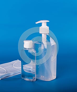 Hand sanitizer dispenser and face mask. blue background. coronavirus concept