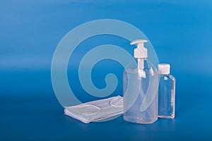 Hand sanitizer dispenser and face mask. vivid blue background. coronavirus concept