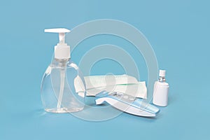 Hand Sanitizer, mask, soap and thermometer on blue
