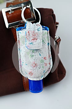 Hand sanitizer pouch with blue bottle cap on handbag fashion