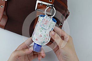 Hand sanitizer pouch with blue bottle cap on handbag fashion