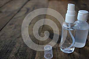 Hand sanitizer spray bottles on wooden table background with copy space. Pandemic protective supply.