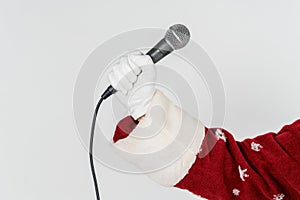 The hand of Santa Claus is holding a microphone in his hand.  on white