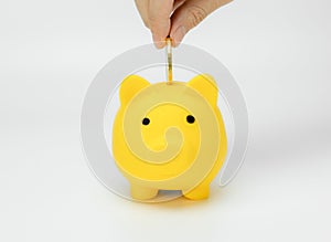 Hand saving money in piggy bank