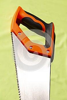 hand saw on a light green background. Construction tools