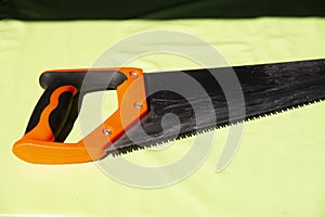 hand saw on a light green background. Construction tools