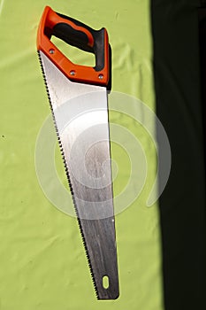hand saw on a light green background. Construction tools