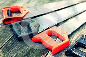 Hand saws well used on wooden boards background, retro concept