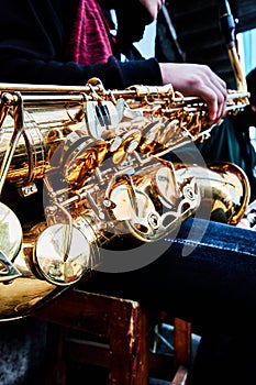 Hand and saxophone details in a band, music show