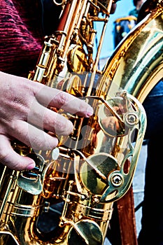 Hand and saxophone details in a band, music show