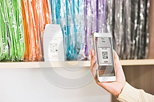 Hand scanning qr code with smartphone on showcase