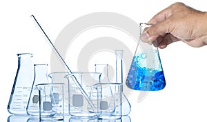 Hand scientist shaking Erlenmeyer flask with blue liquid isolated on white background