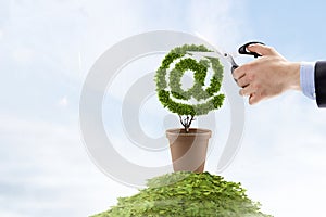 Hand with scissors cutting grass