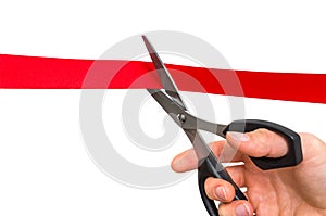 Hand with scissors cutting red ribbon - opening ceremony