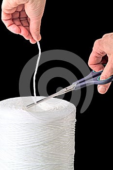 Hand with scissors and polypropylene thread