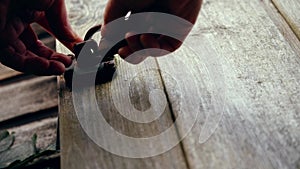 Hand securing old wooden shed with padlock