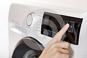 The hand select settings for laundry on modern digital display. Close-up view of automatic washing machine with touch screen on