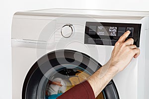 The hand select settings for laundry on modern digital display. Close-up view of automatic washing machine with touch screen on
