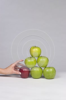 Hand selecting an apple from a stack