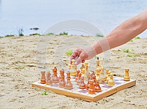 A hand of senior man making a move in a game of chess