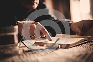 Hand of senior man reading book in nursing home