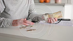 Hand Of Senior Woman Counting Euro Cash Banknotes And Coins At Home