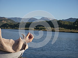 Hand senior woman yoga and lotus pose meditation and relax in the mountan lake. Healthy and Zen Concept Close up