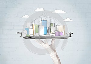 Hand serving city and clouds on tray