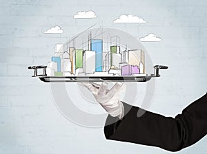 Hand serving city and clouds on tray