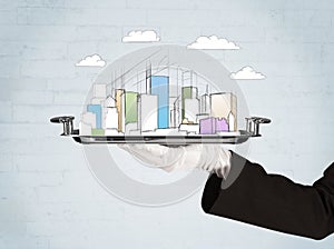 Hand serving city and clouds on tray