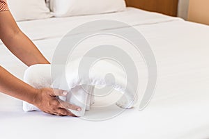 Hand set up white bed sheet in hotel room